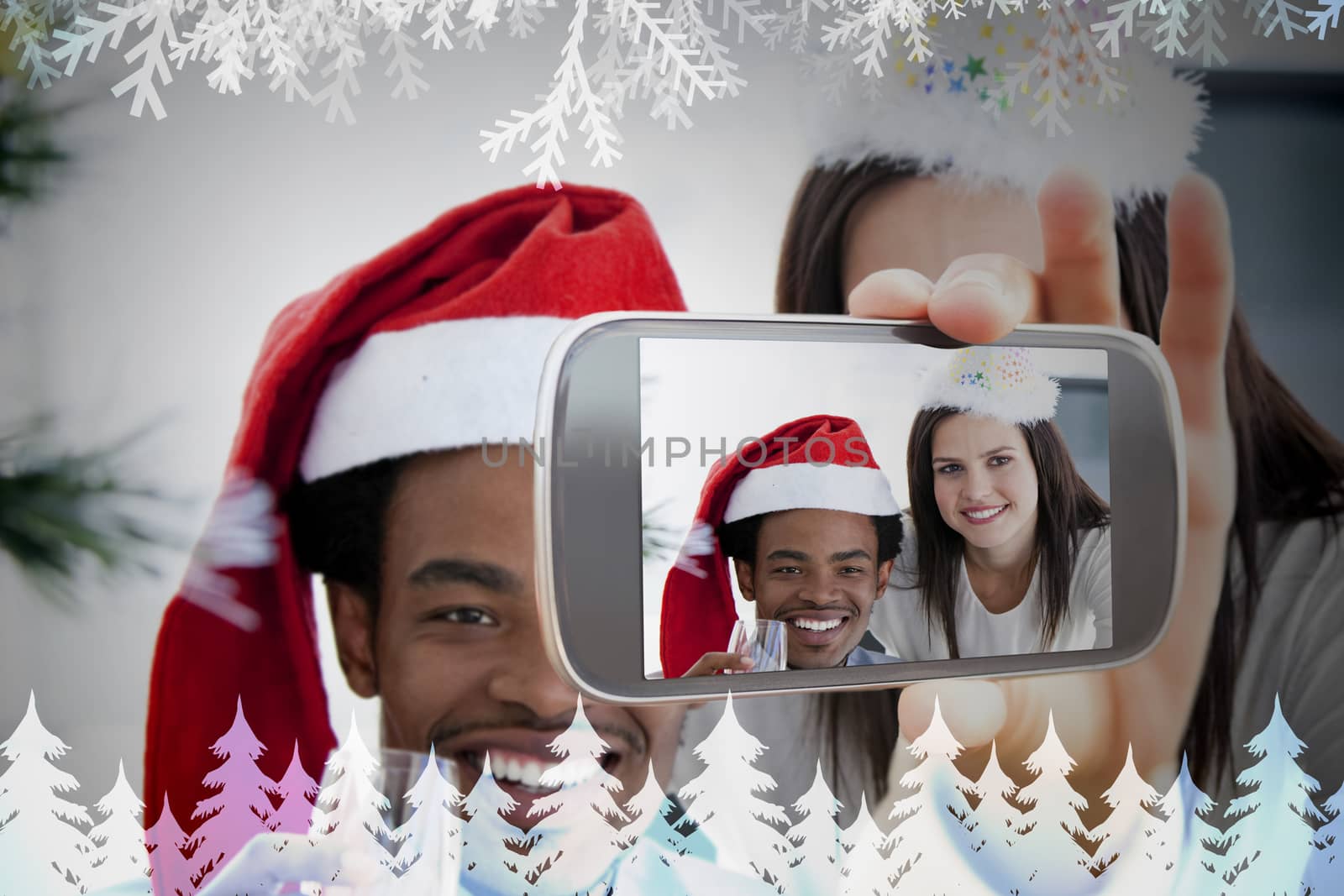 Hand holding smartphone showing photo against frost and fir trees in blue