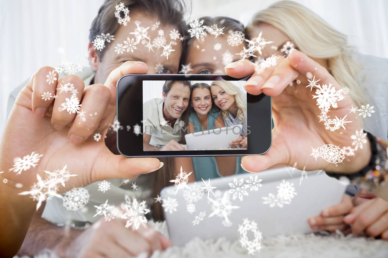 Hand holding smartphone showing photo against snow