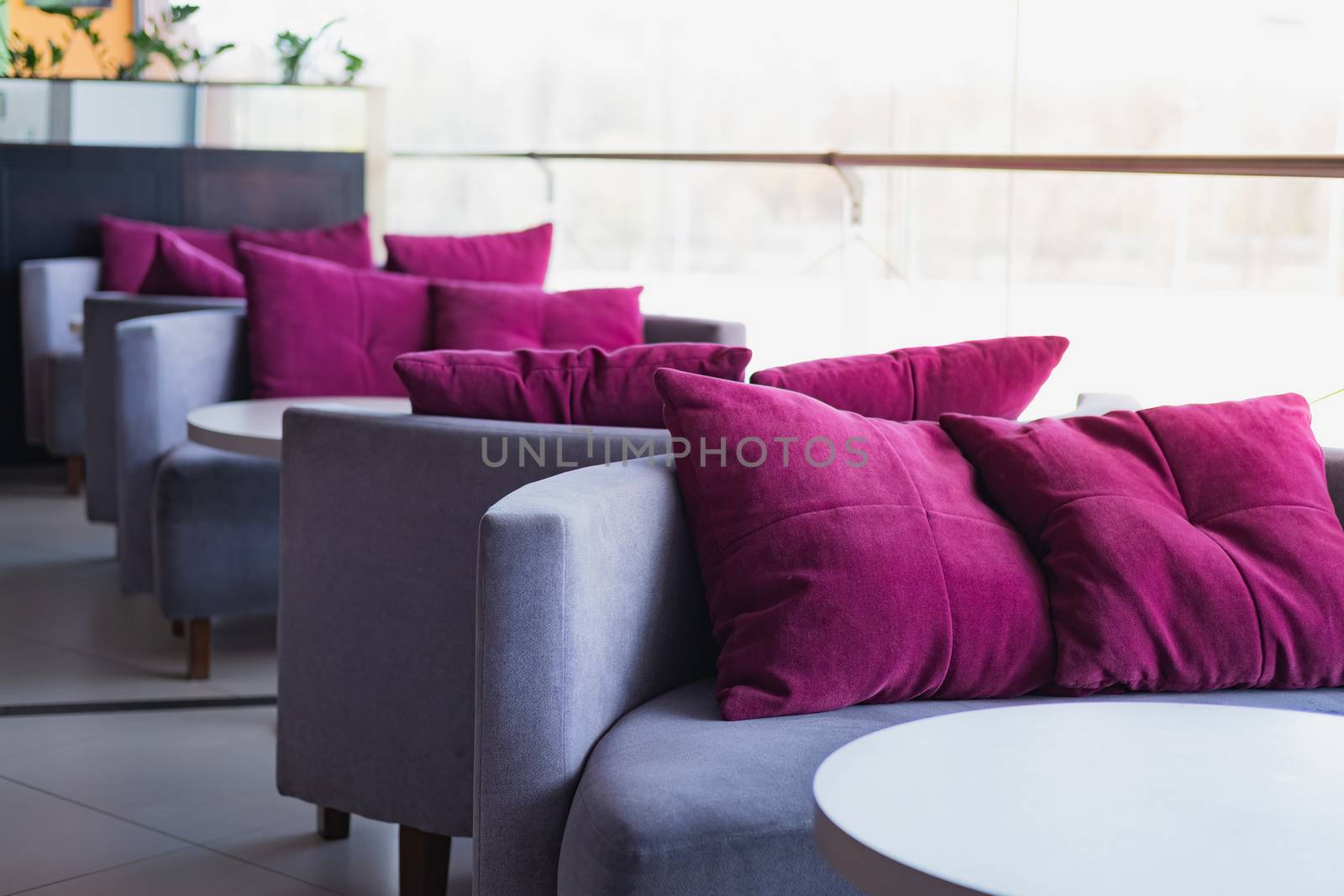Empty cushions and sofas at a generic cafe. Clean table and chairs against the bright light, generic interior, concept of lockdown due to quarantine