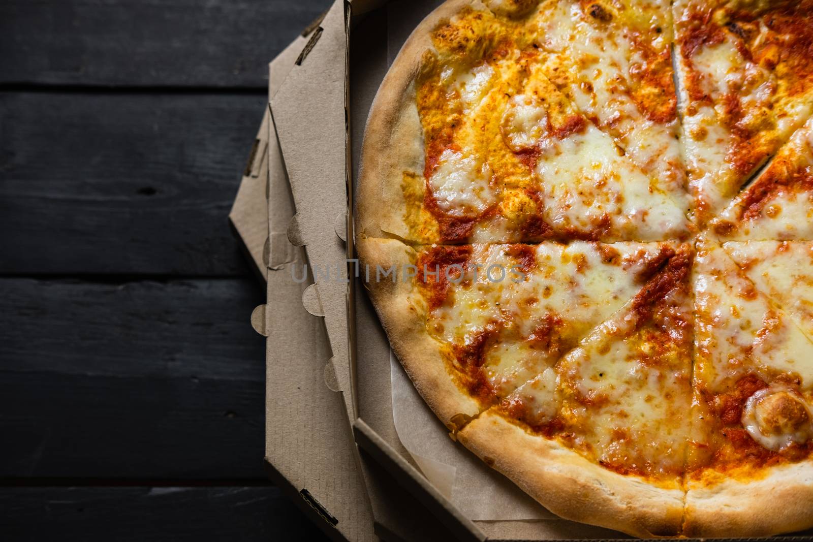 Cold pizza in a delivery box, long delivery times, wasted fast food concept. Italian pizza margherita with dry crust and sauce, delayed or failed food delivery service