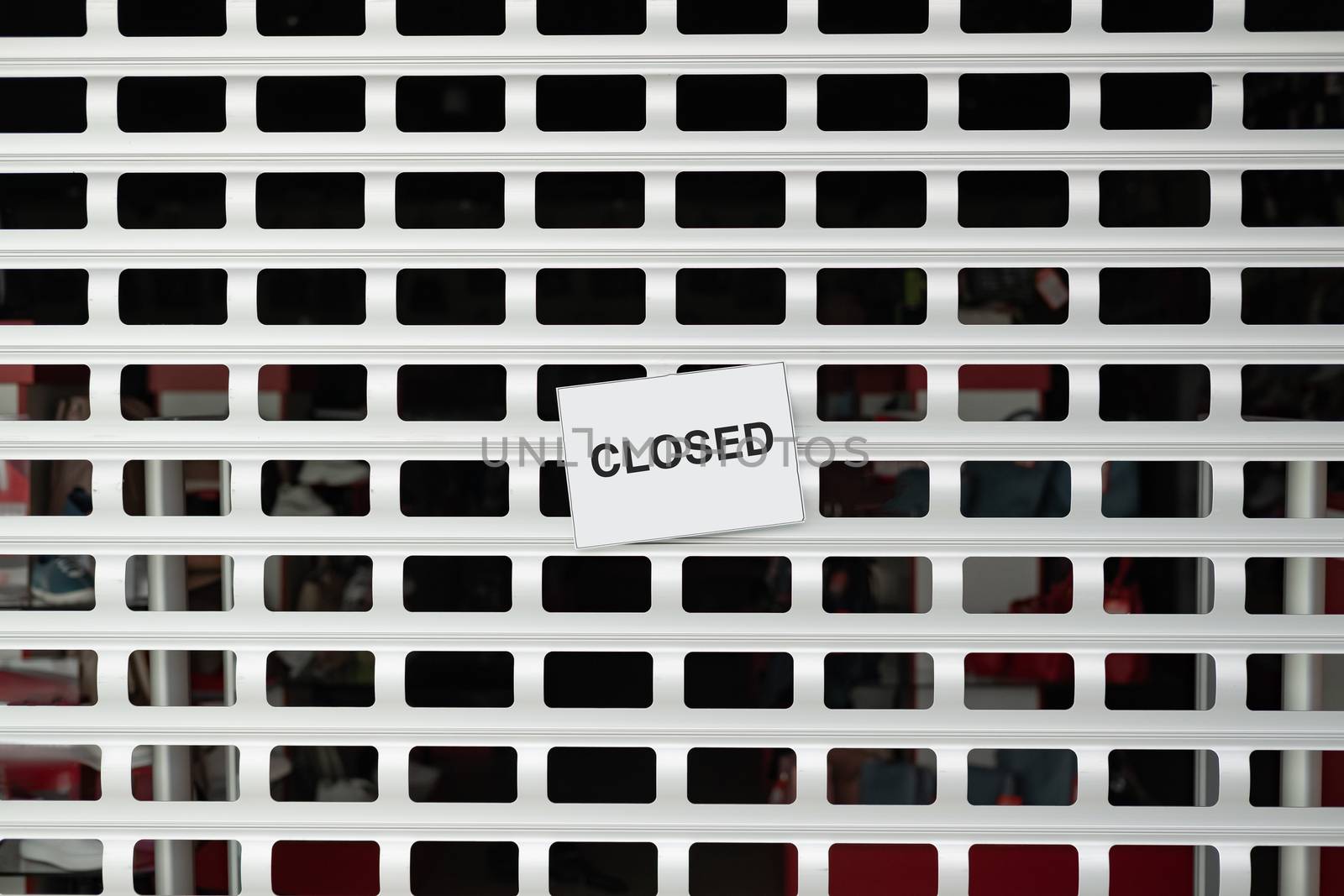 The sign "closed" on roller blinds of a shop. Concept of retailer stores and shops shut down due to quarantine