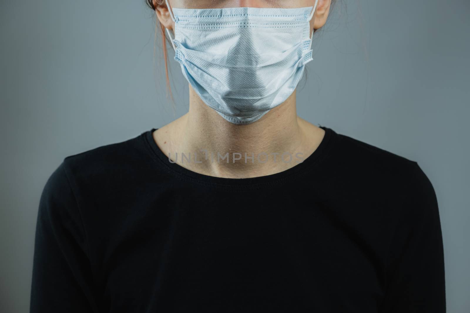 Female person in a surgical mask, minimalist and generic image.  by photoboyko