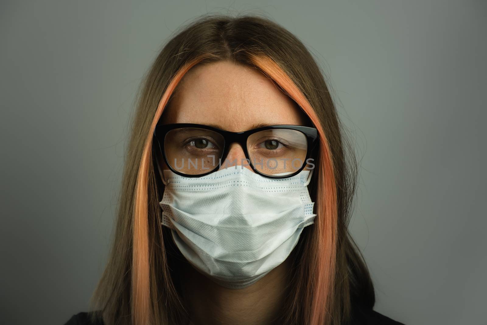 Intelligent woman in eyeglasses wearing medical mask. by photoboyko