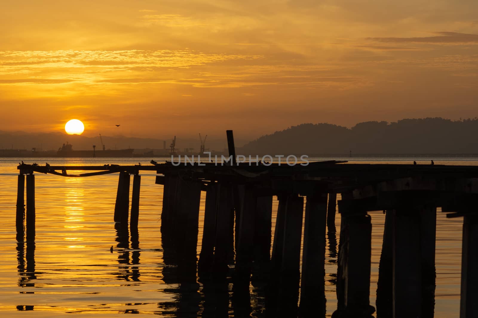 Beautiful sunrise over the sea near the wooden Bridge at fisherman jetty Penang, Malaysia.