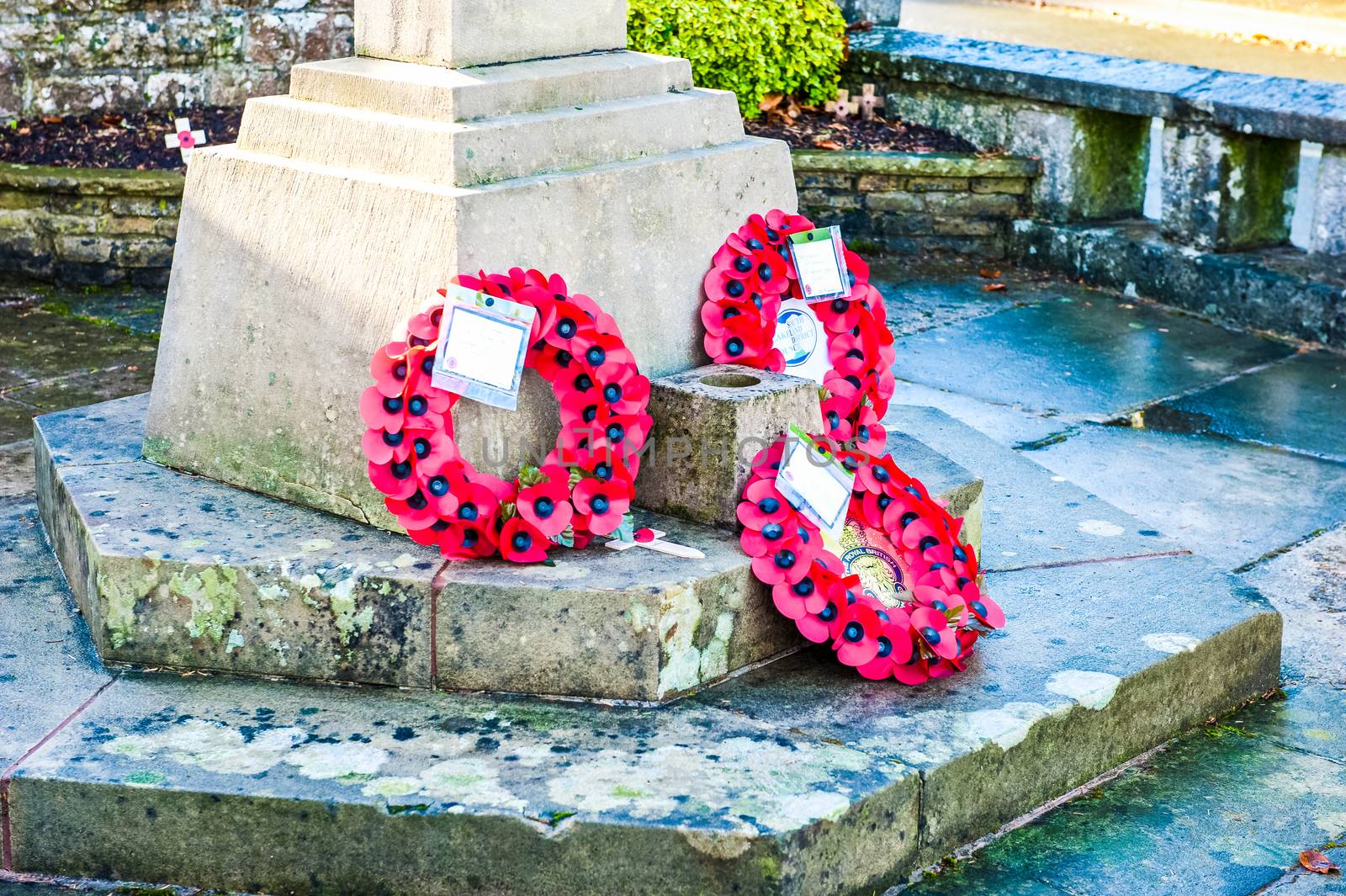 Poppy wreaths laid at the foot of the war memorial in remembrance of fallen soldiers and members of the armed forces by paddythegolfer