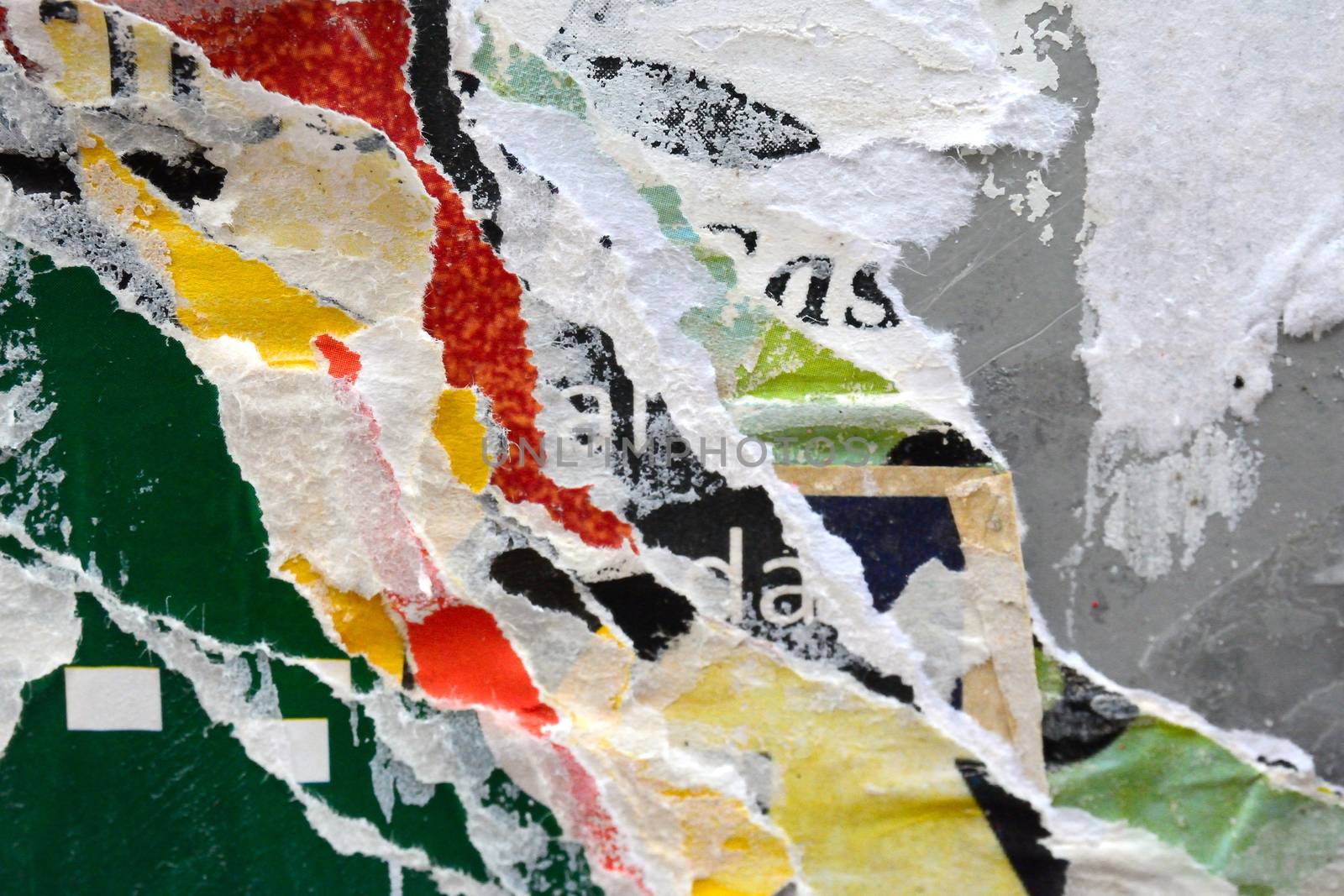 A colourful photo of textures created by layers of torn advertising posters on a billboard background