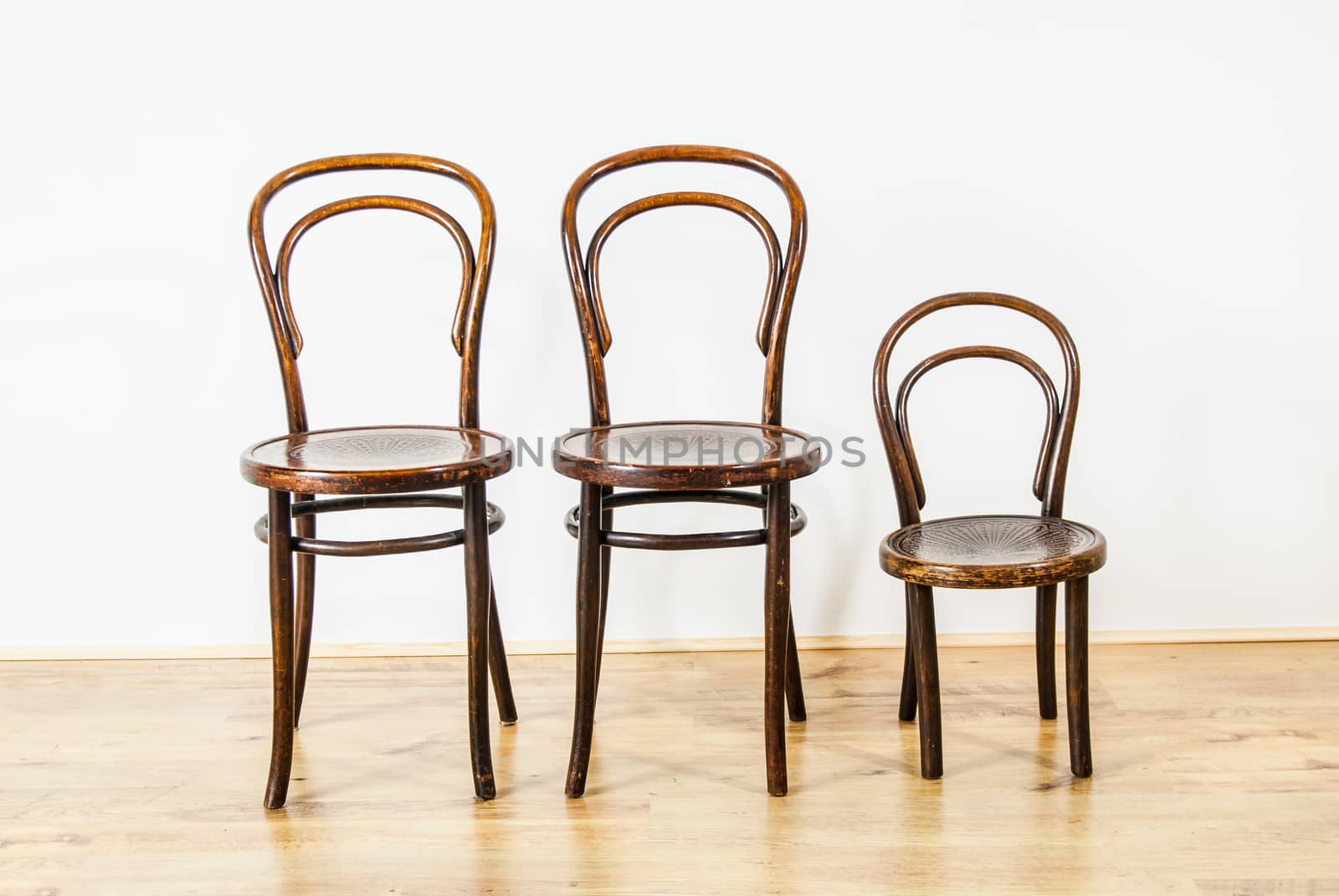 two large and one childs chair in an empty room UK