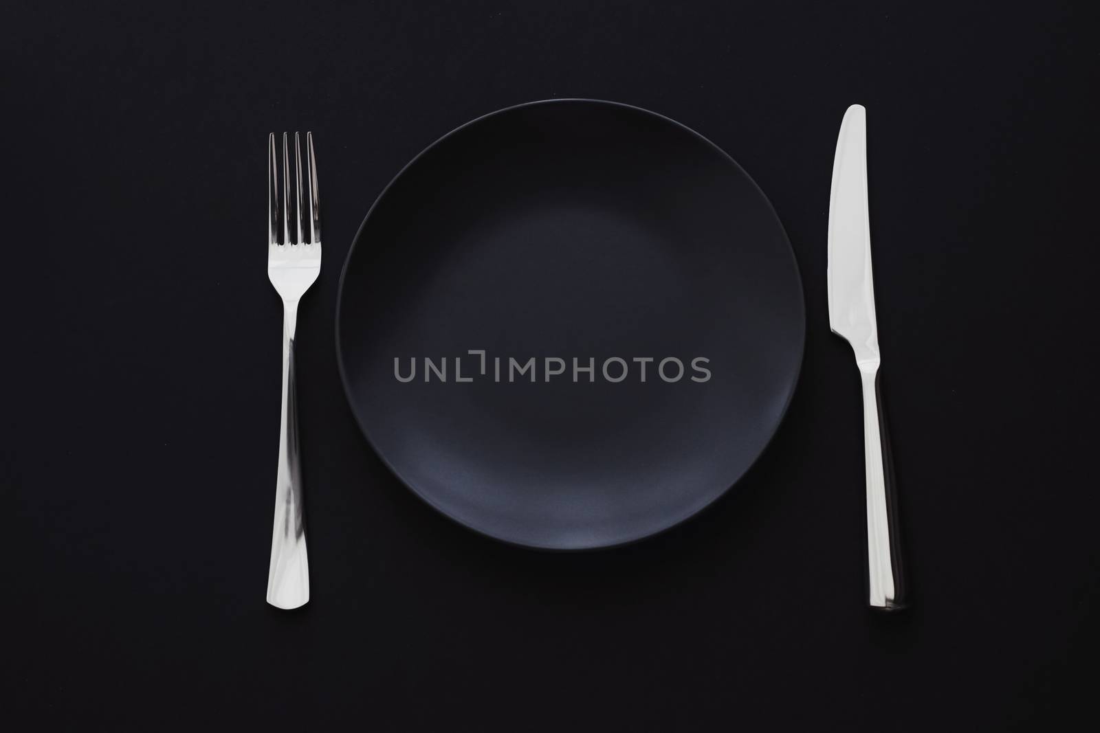 Empty plates and silverware on black background, premium tableware for holiday dinner, minimalistic design and diet concept