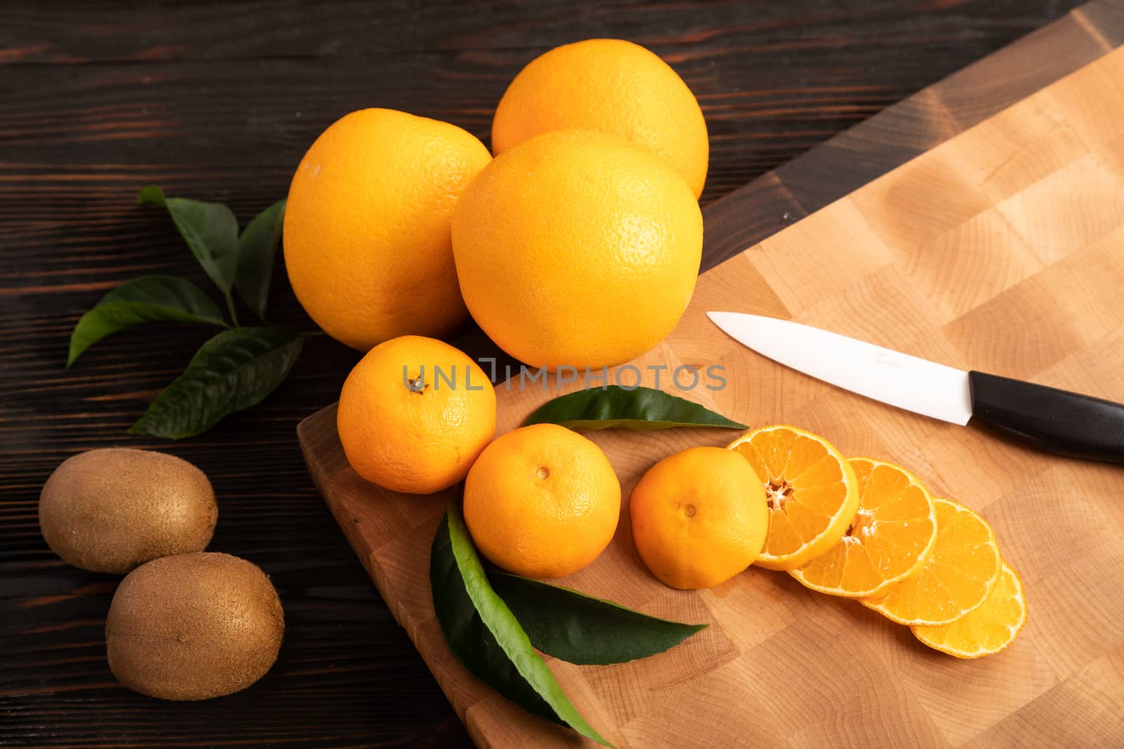 Sliced orange and other fruits on a wooden cutting board by sveter