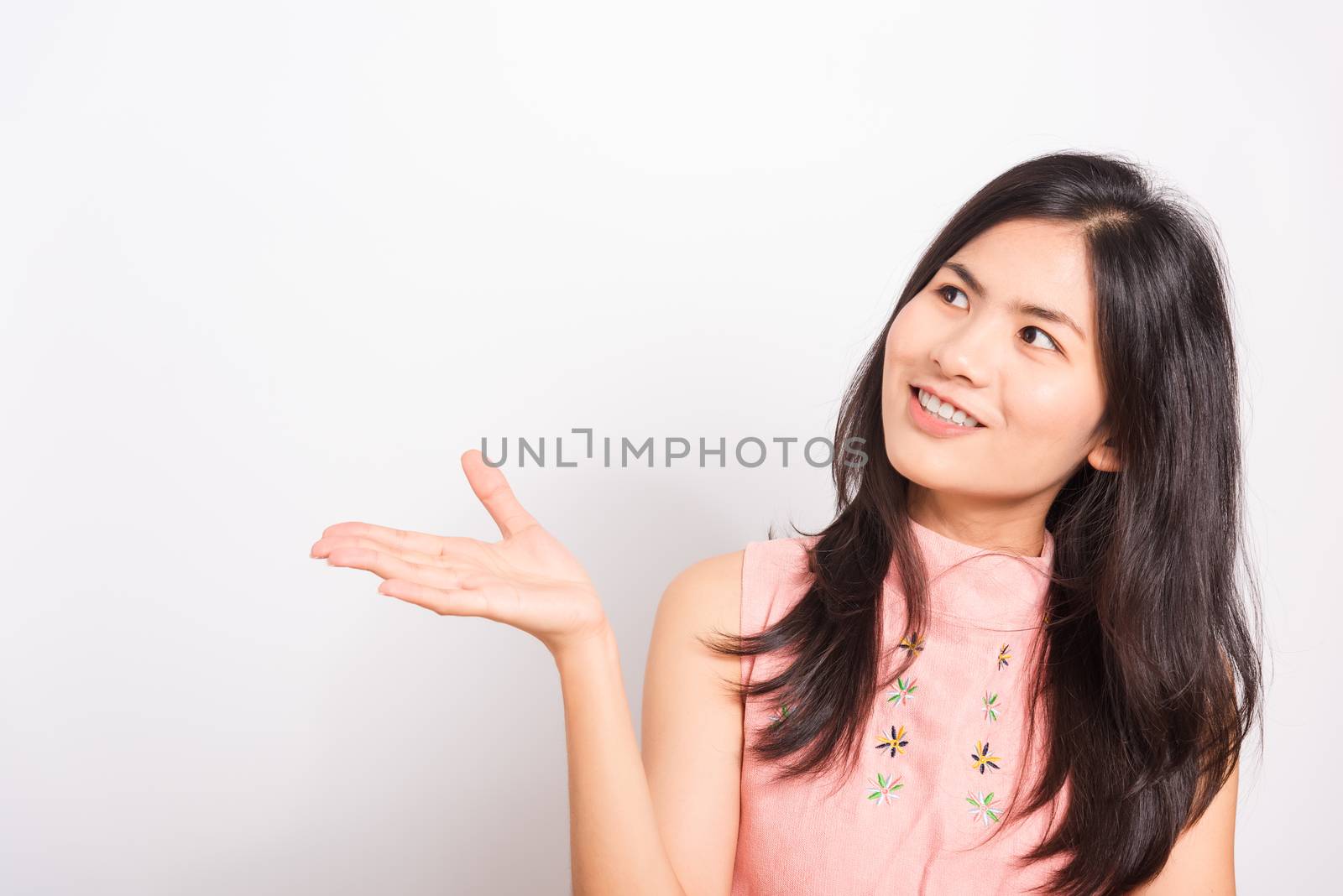 Portrait Asian beautiful young woman standing, She showing hand to presenting product and looking to product, shoot photo in a studio on white background, There was copy space
