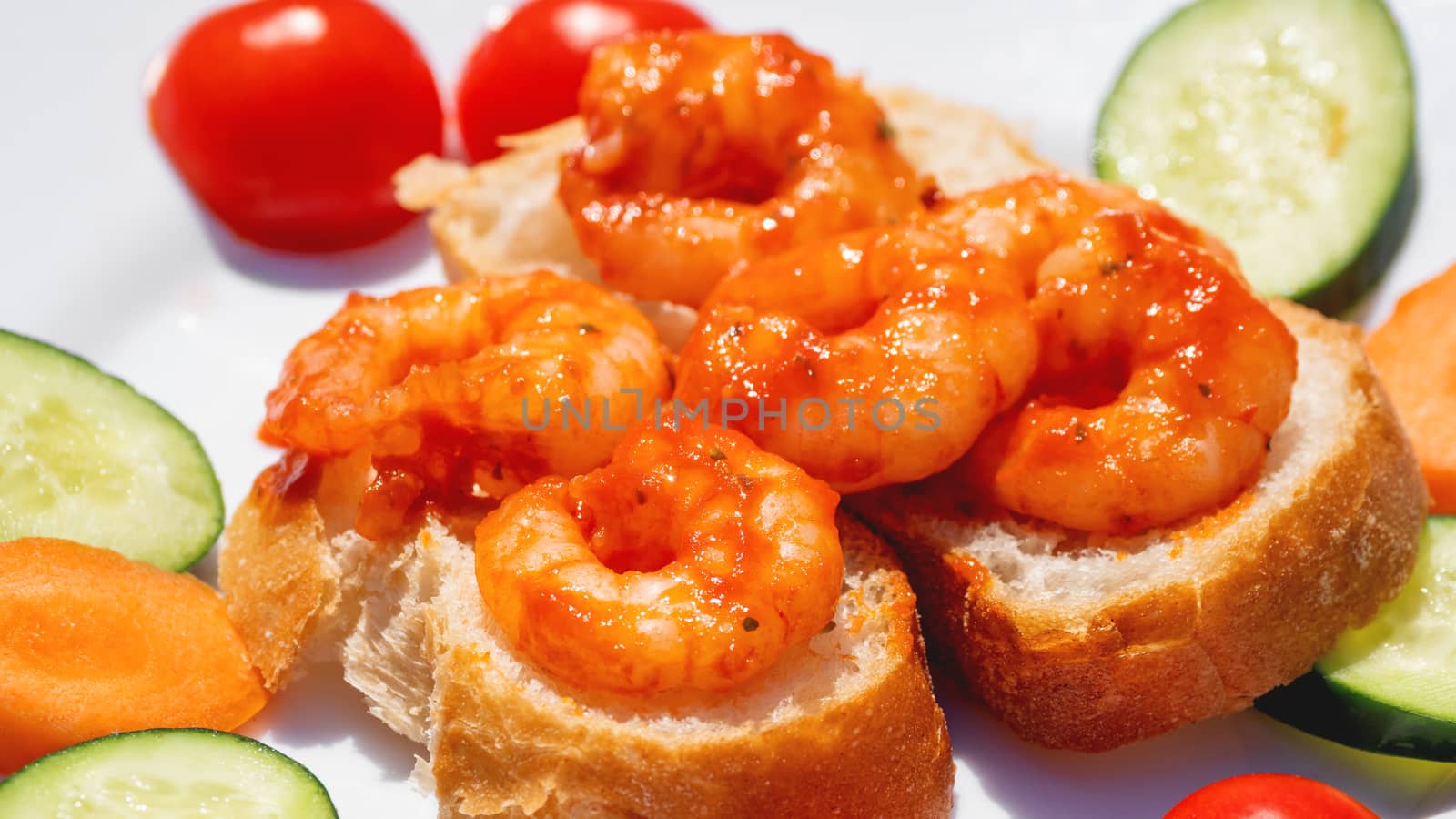 Mediterranean cuisine - freshly cooked shrimps on bread with vegetables. Seafood with cucumbers and tomatoes. by aksenovko