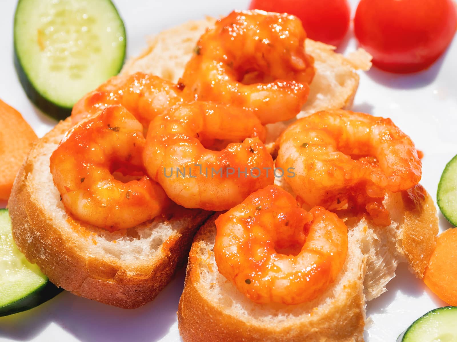 Mediterranean cuisine - freshly cooked shrimps on bread with vegetables. Seafood with cucumbers and tomatoes. by aksenovko