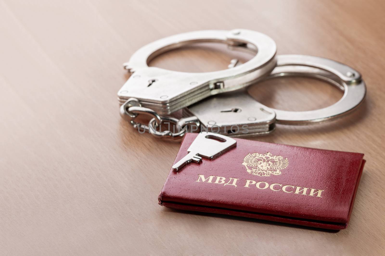 Locked handcuffs with key and certificate of employee of the Ministry of internal Affairs. Concept of legal responsibility for violating isolation regime during the coronavirus COVID-19 quarantine. by aksenovko