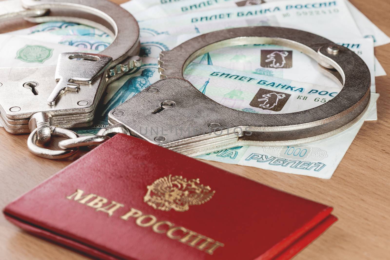 Locked handcuffs, certificate of employee of the Ministry of internal Affairs and Russian banknotes. Legal responsibility and monetary fine for violating isolation during coronavirus COVID-19 quarantine. by aksenovko