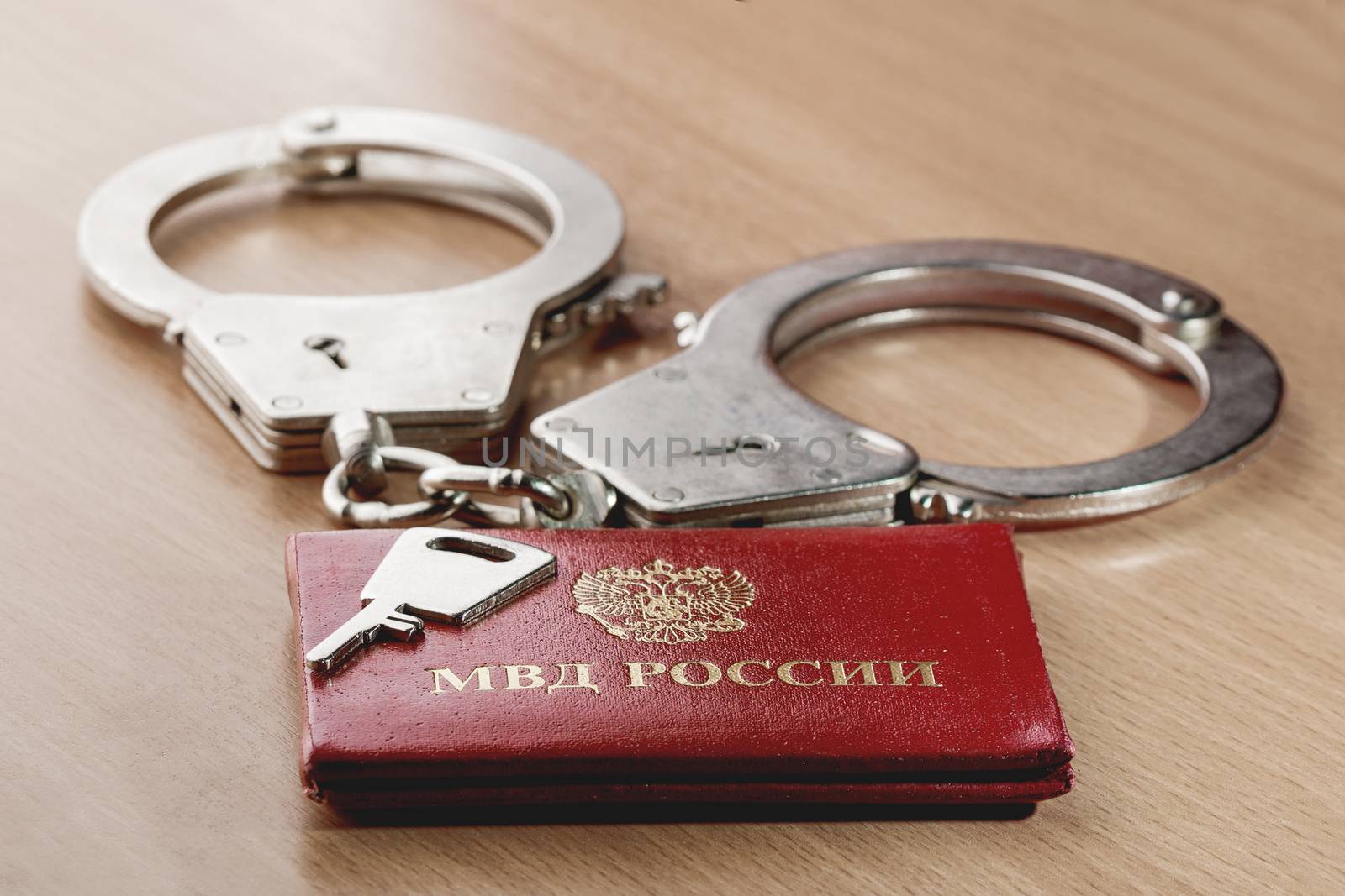 Locked handcuffs with key and certificate of employee of the Ministry of internal Affairs. Concept of legal responsibility for violating isolation regime during the coronavirus COVID-19 quarantine. by aksenovko