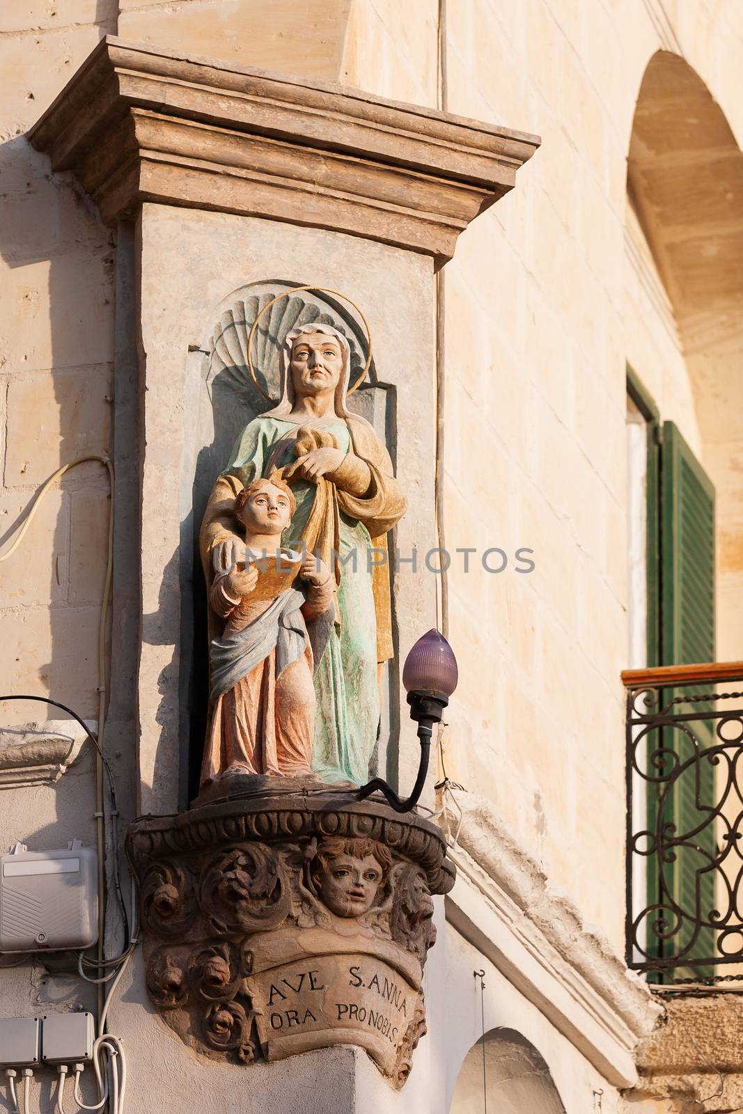 Statue of woman and child on corner of building. Latin inscription is a request to Saint Anne to pray for her worshippers. Malta. by aksenovko