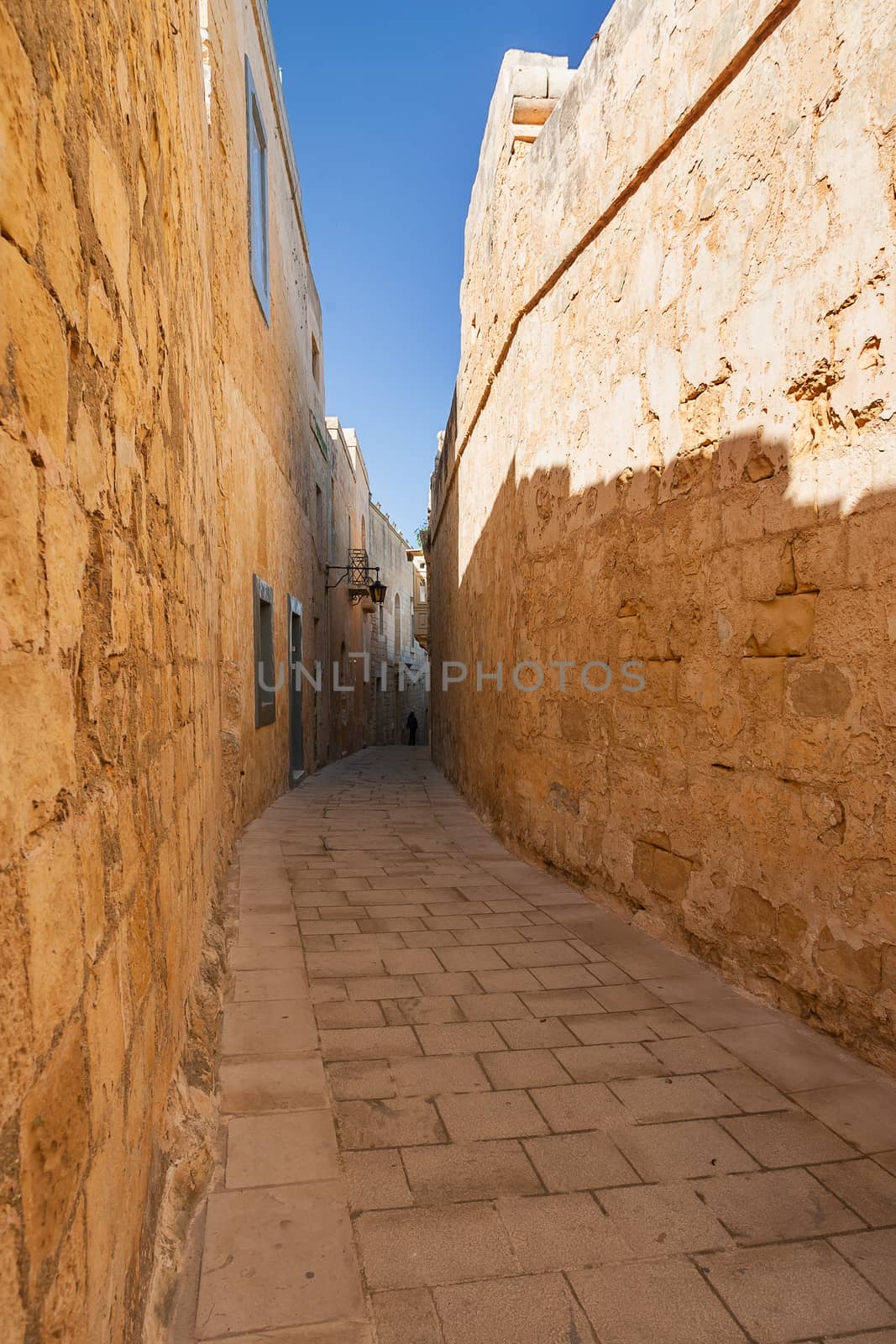 Narrow streets of Mdina, old capital of Malta. Stone buildings with old fashioned doors and balconies.