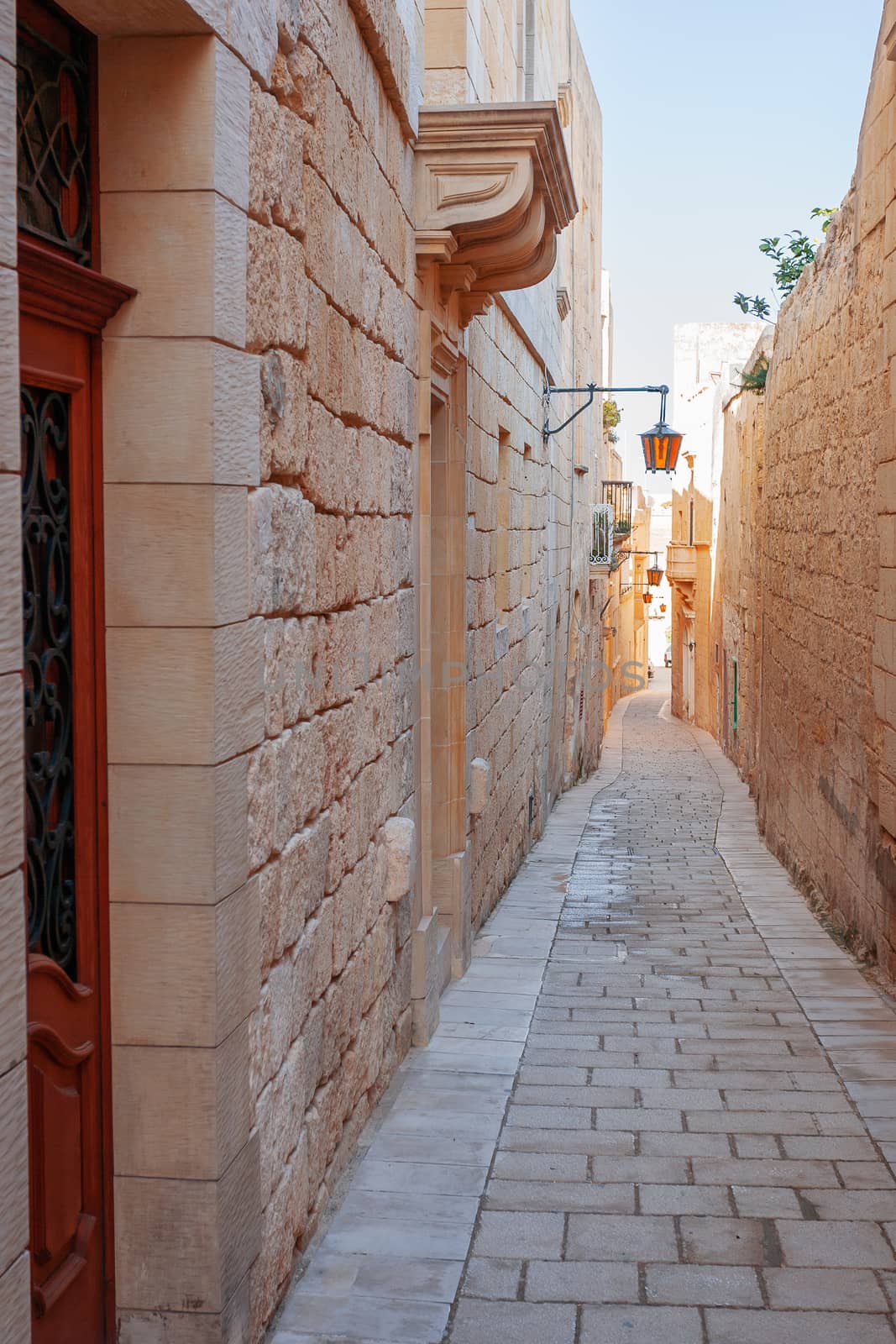 Narrow streets of Mdina, old capital of Malta. Stone buildings with old fashioned doors and balconies. by aksenovko