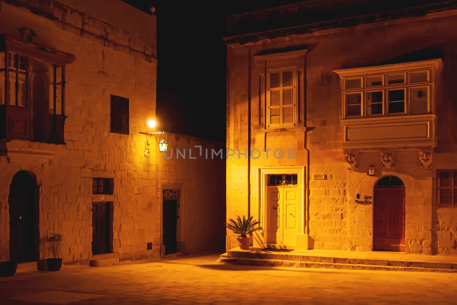 Illuminated streets of Mdina, ancient capital of Malta. Night view on buildings and wall decorations of ancient town.