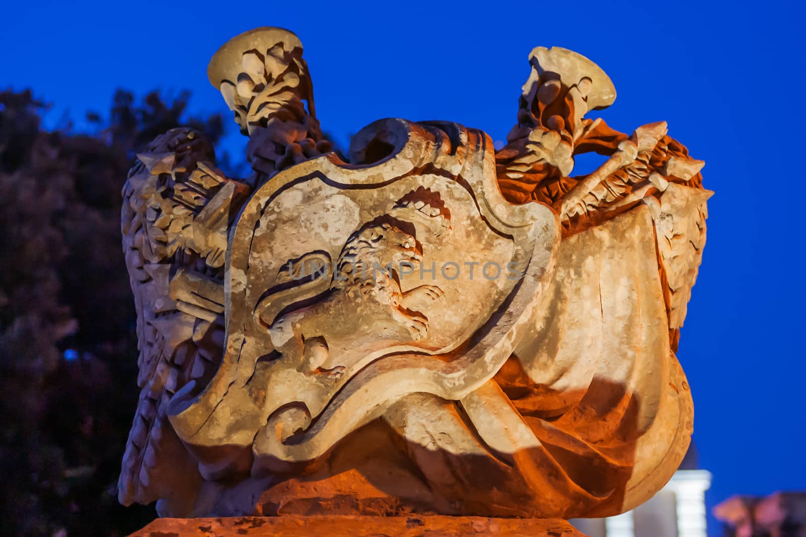 Illuminated coat of arms with heraldic lion. Architectural detail of main gated in Mdina, ancient capital of Malta. by aksenovko