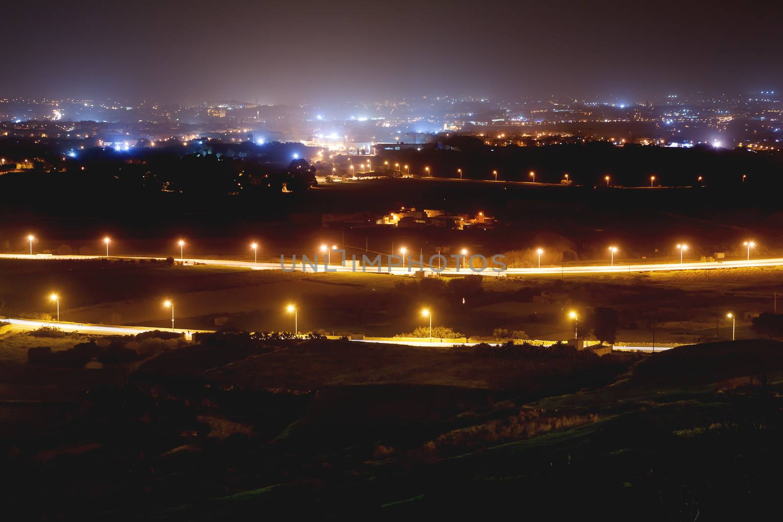 Night panorama view of illuminated roads and grounds around Mdina - old capital of Malta. Shooted with long exposure. by aksenovko