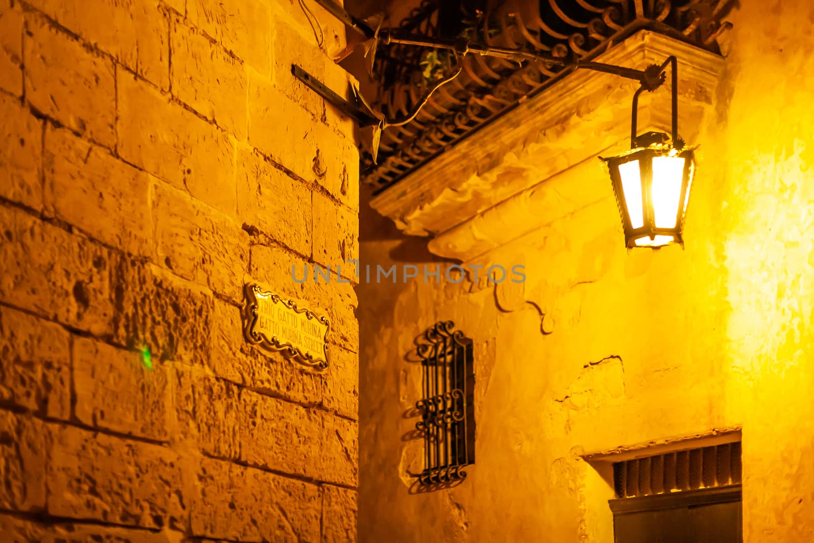 Narrow streets of Mdina, ancient capital of Malta. Night view on illuminated buildings and wall decorations of ancient town. by aksenovko