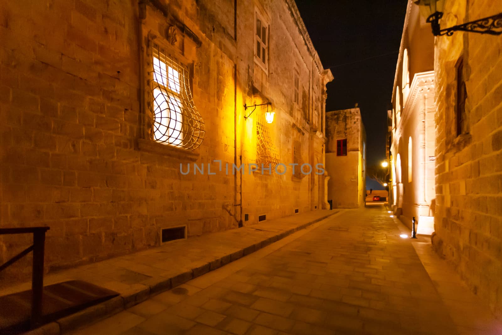 Narrow streets of Mdina, ancient capital of Malta. Night view on illuminated buildings and wall decorations of ancient town. by aksenovko