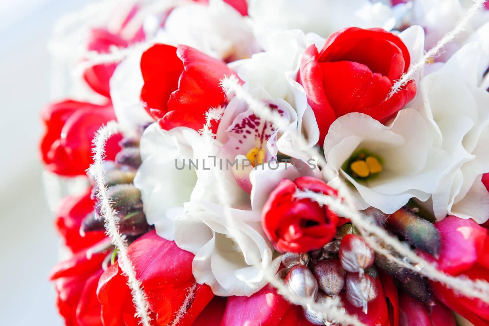 Bridal bouquet on sunlight. Traditional floral composition with bright red tulips. by aksenovko