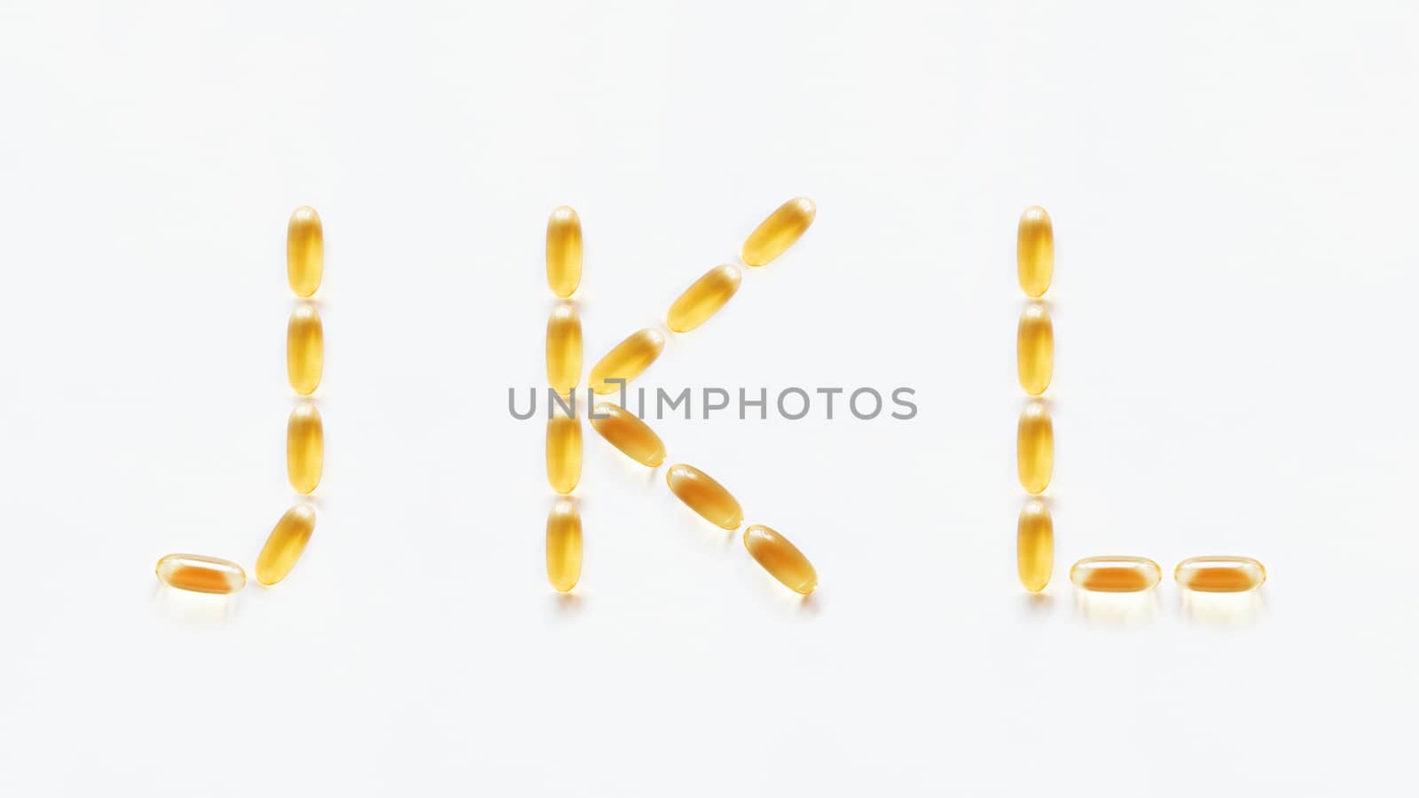 Letters J, K, L made of transparent yellow pills. Part 4 of latin alphabet in medical style. Isolated on white background.