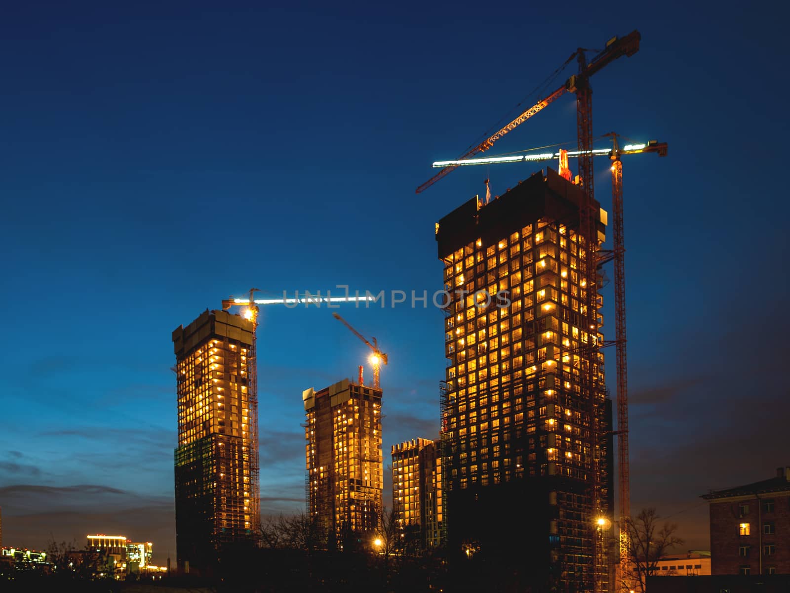 Night view on construction site. Construction cranes near future high-rise apartment building. Moscow, Russia.