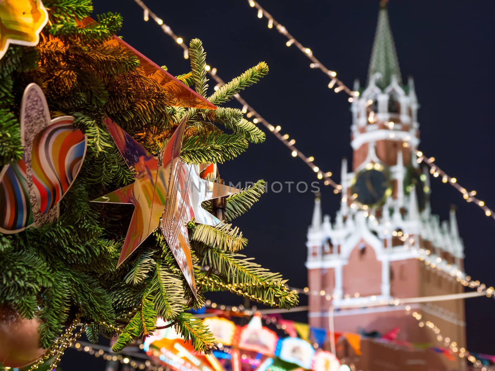 Decorative star on Christmas tree. New Year fair on Red square in Moscow. Spasskaya tower of Kremlin on background. Russia.