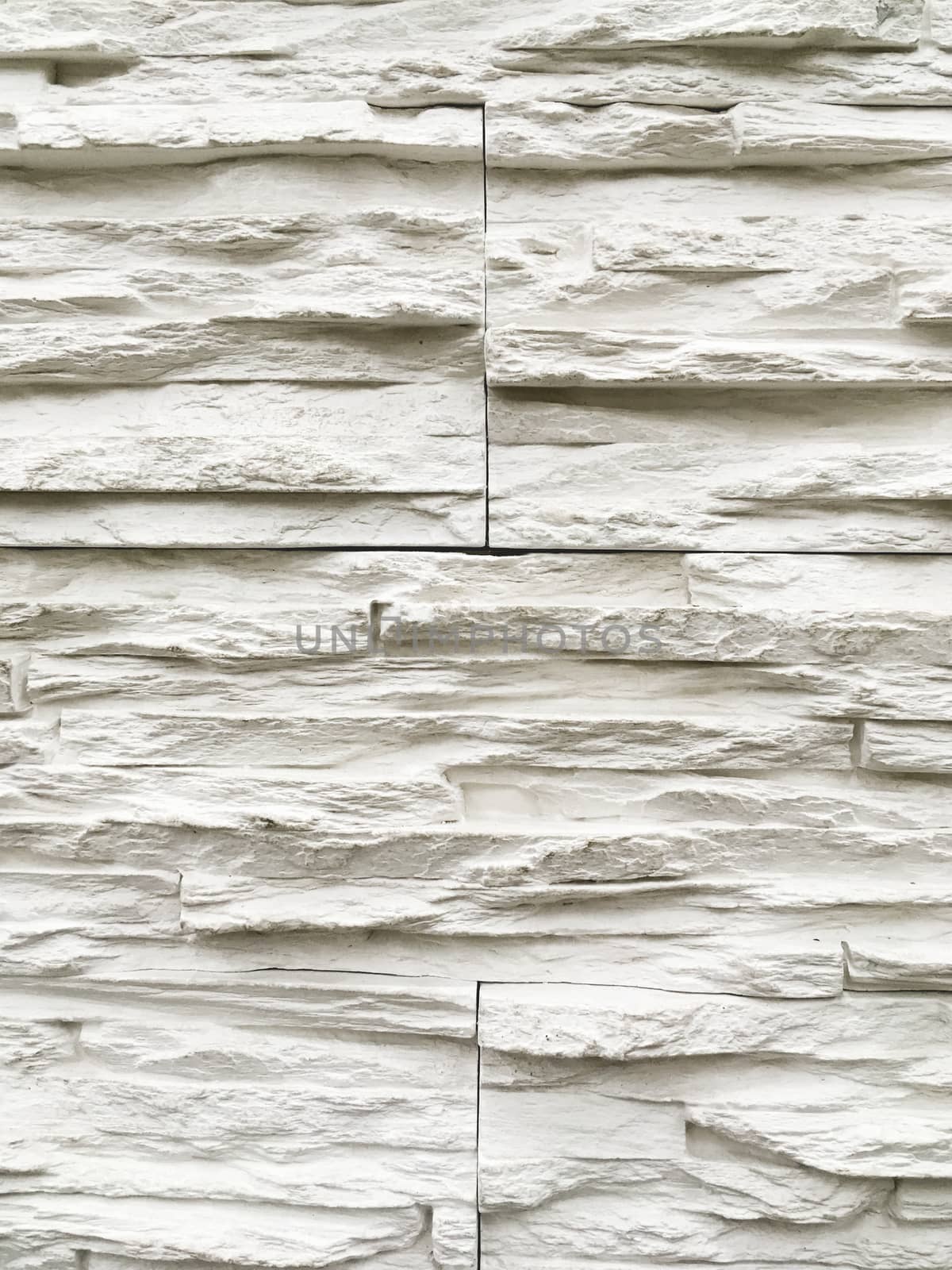 Outdoor wall made of white decorative stones. Stone texture of building wall.