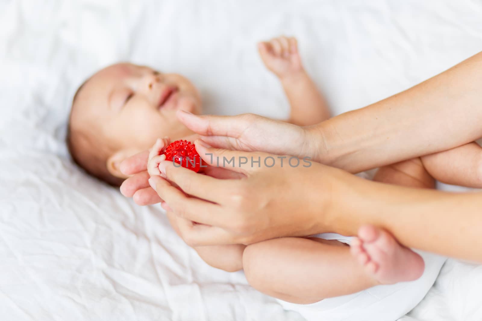 Mother holds newborn baby's palm hands. Tiny fingers in woman's hand. Cozy morning at home. by aksenovko