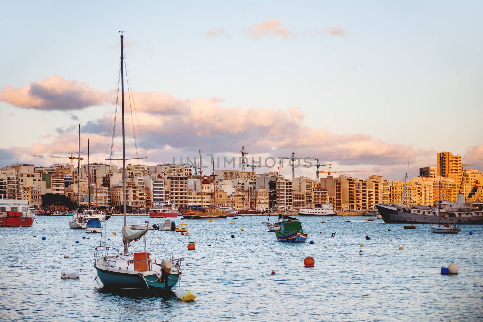 Sliema seaside and moored sailing ships. Yachts and sunset panorama view of Sliema, Malta.