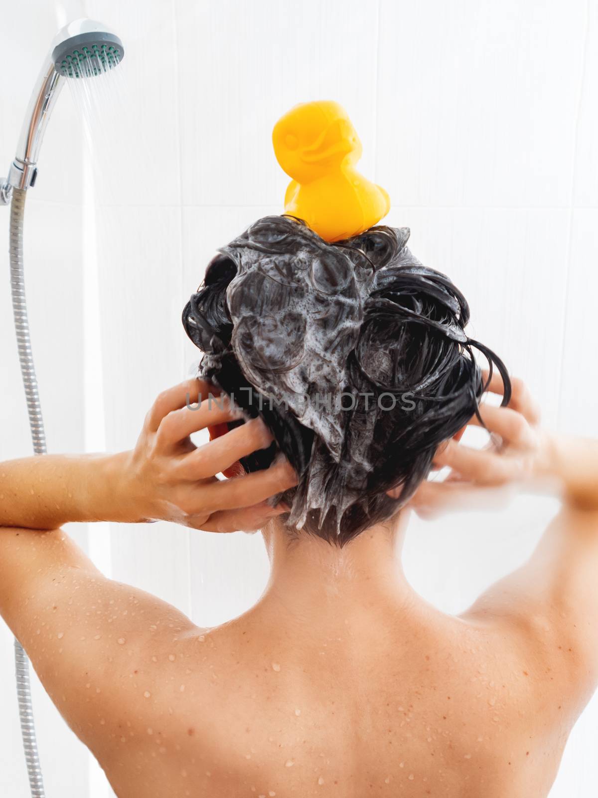 Naked woman with short hair takes a shower. Woman washes her hai by aksenovko