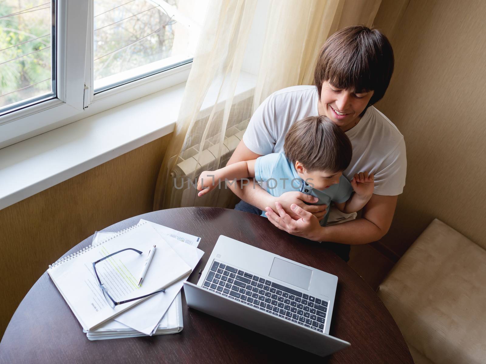 Self-isolation because of coronavirus outbreak. Man is remote working with his little son on self quarantine. Lockdown.