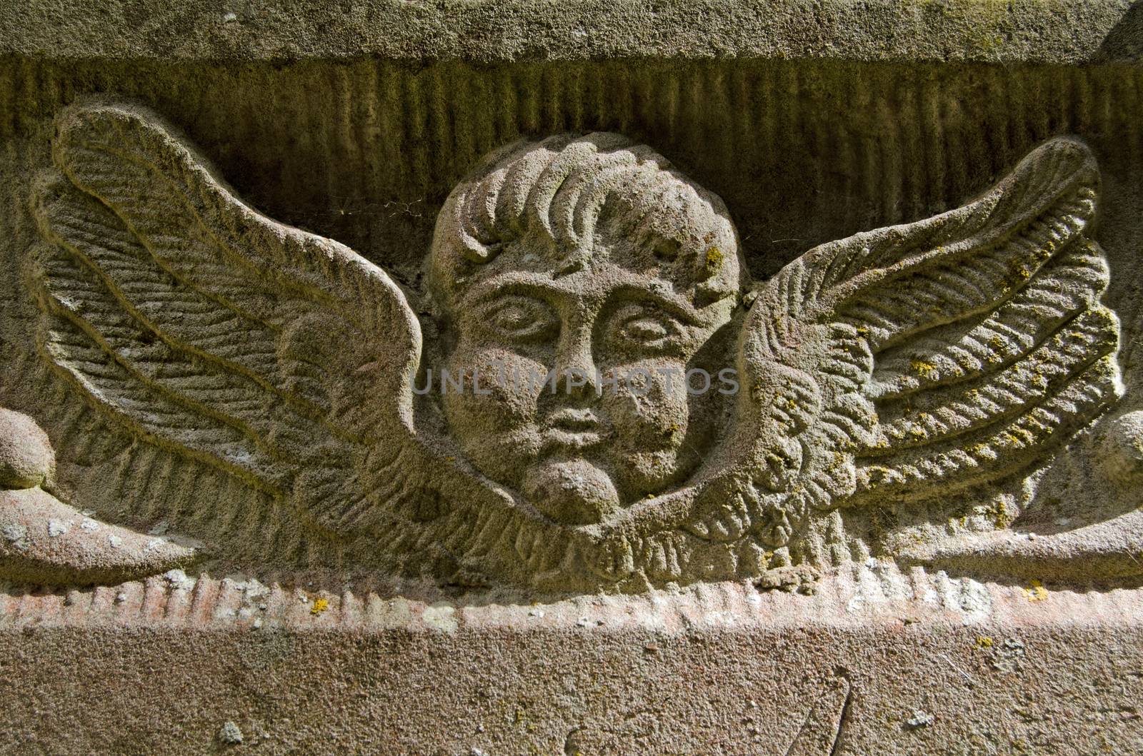 Detail of a memorial from Georgian times showing an angel carved into stone.   Exterior wall of an historic church on public display over 150 years.  