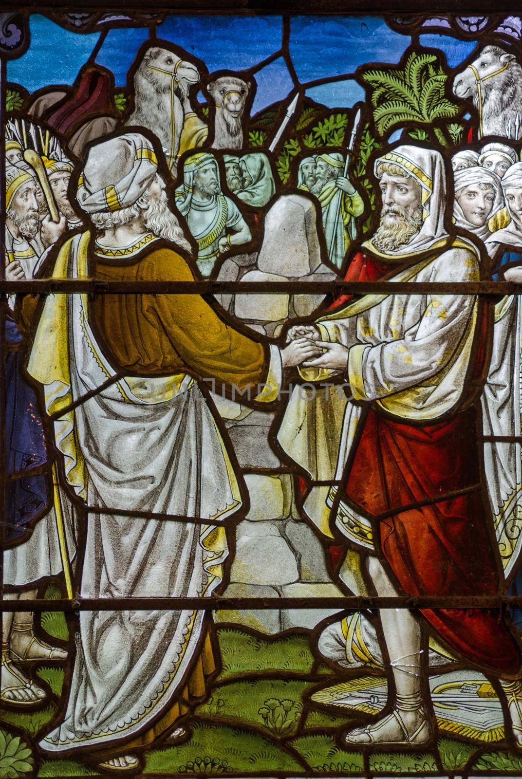 A Victorian stained glass window showing two men making an emotional agreement or Mizpah as described in the Old Testament parable of Jacob and Laban. Historic window on public display over 100 years.
