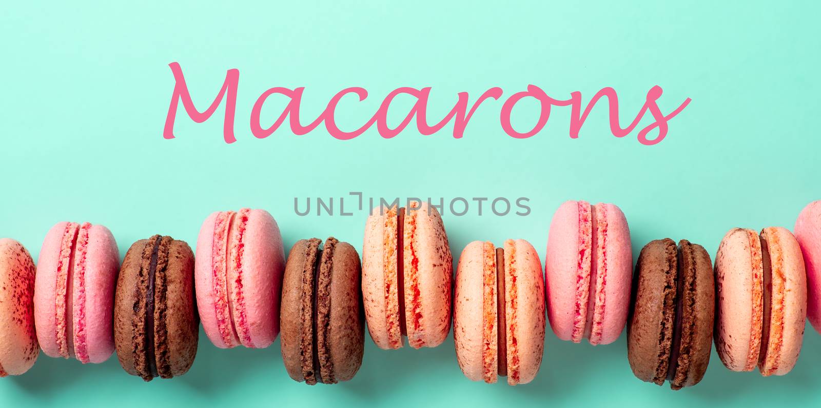Macarons concept. Letters macarons on turquose bright bacground and row of french macarons