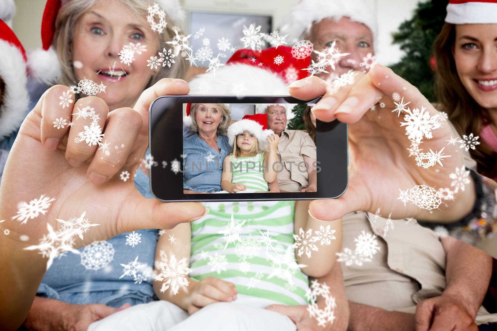 Hand holding smartphone showing photo against snow