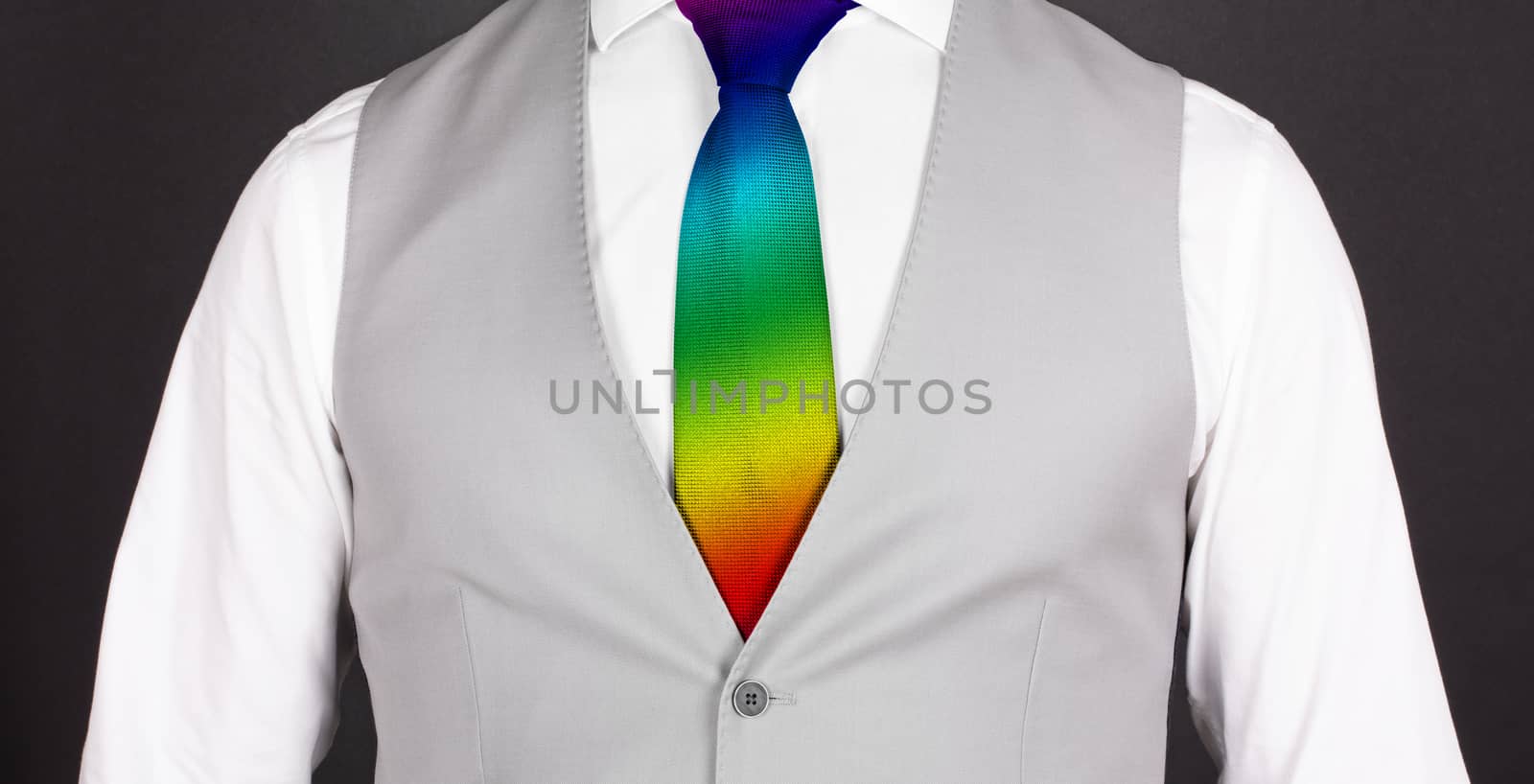 Man in a grey suit with rainbow colored tie, close-up