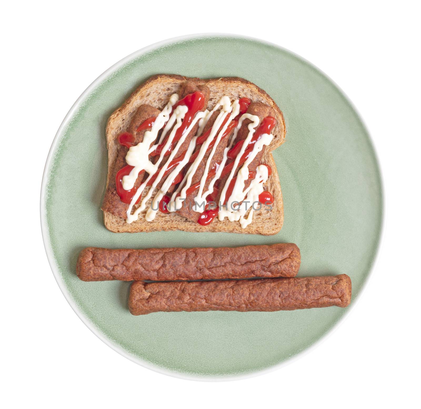 Chopped up frikadel with ketchup and mayonnaise on a piece of bread, on a plate, a Dutch fast food snack