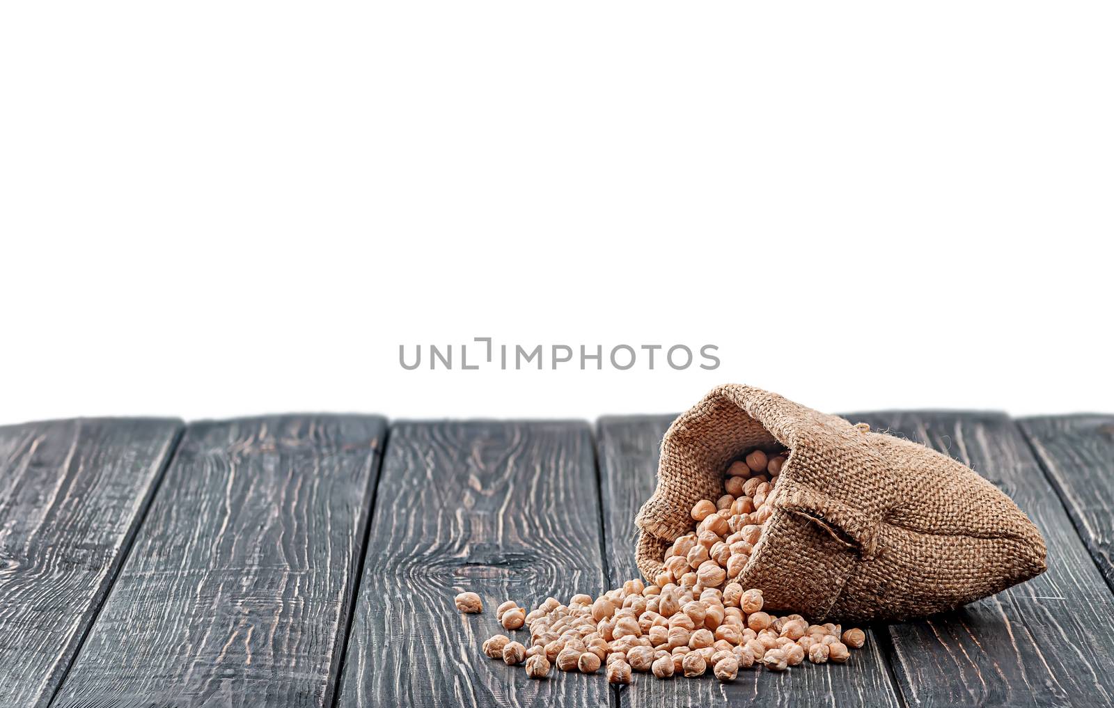 Chickpea spill out of the bag on table isolated on white background
