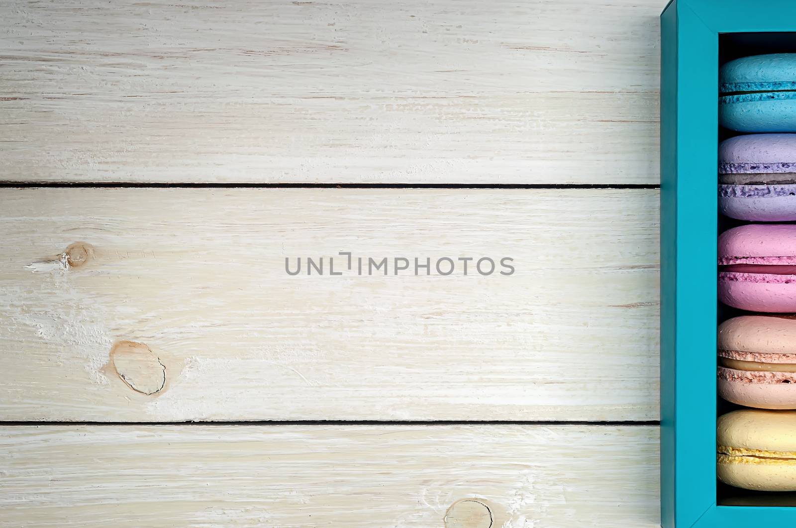 Macaroons in gift box on a wooden background