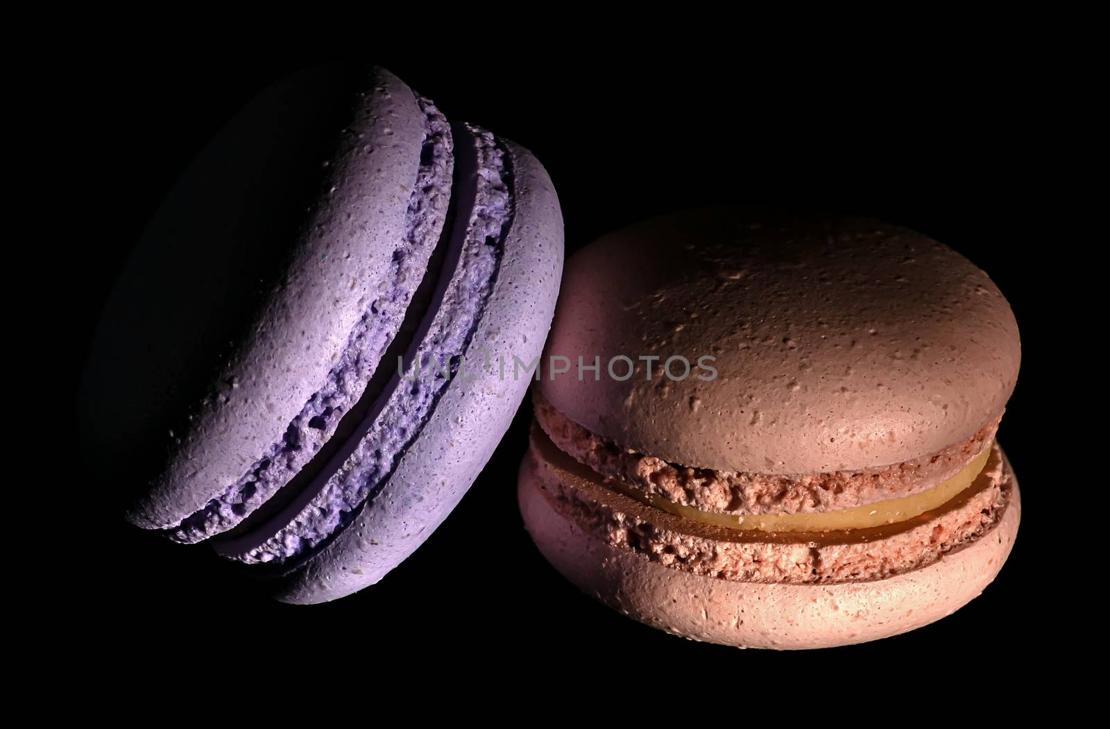 Two macaroons darkened on a black background