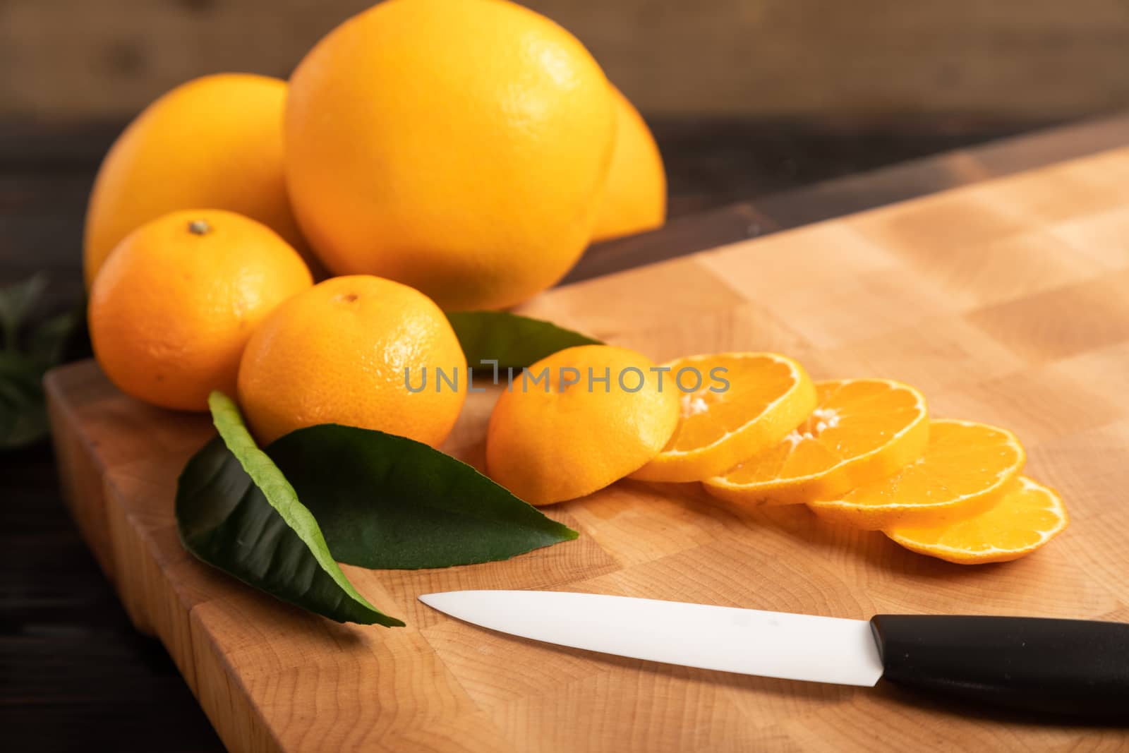 Sliced orange and other fruits on a wooden cutting board by sveter