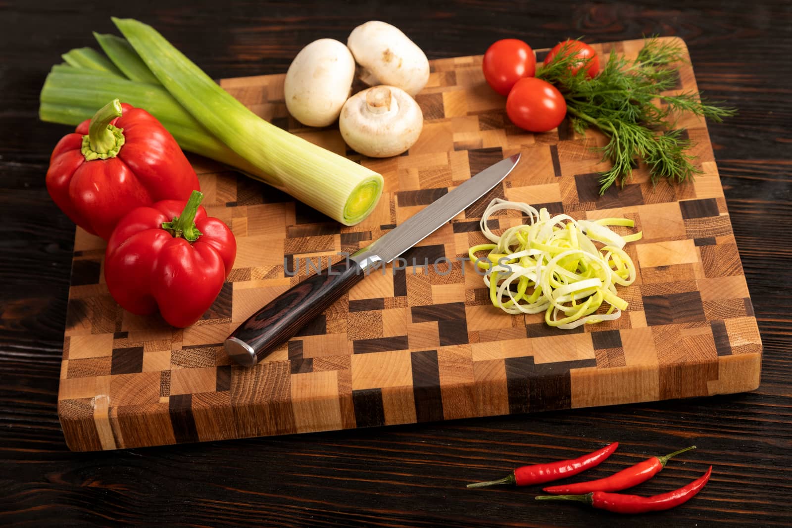 Knife vegetables and spices on a wooden cutting board