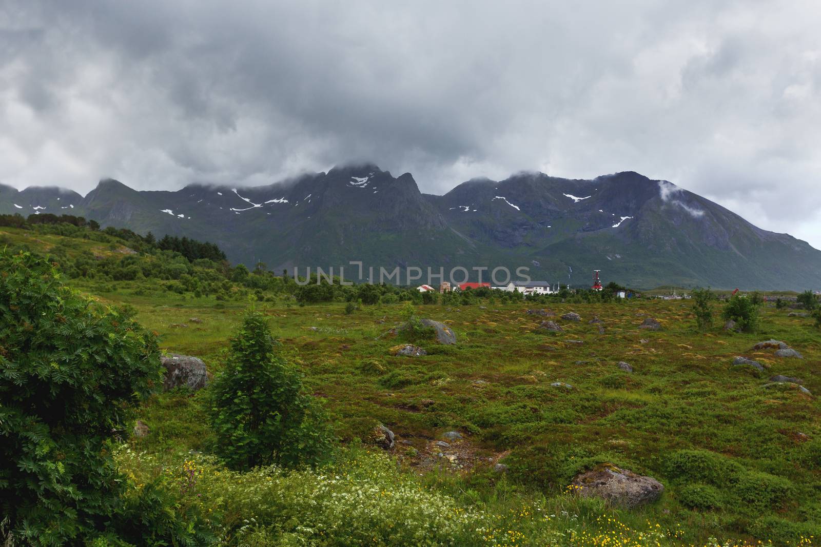 Typical scandinavian landscape with meadows, mountains and village. Lofoten islands, Norway.