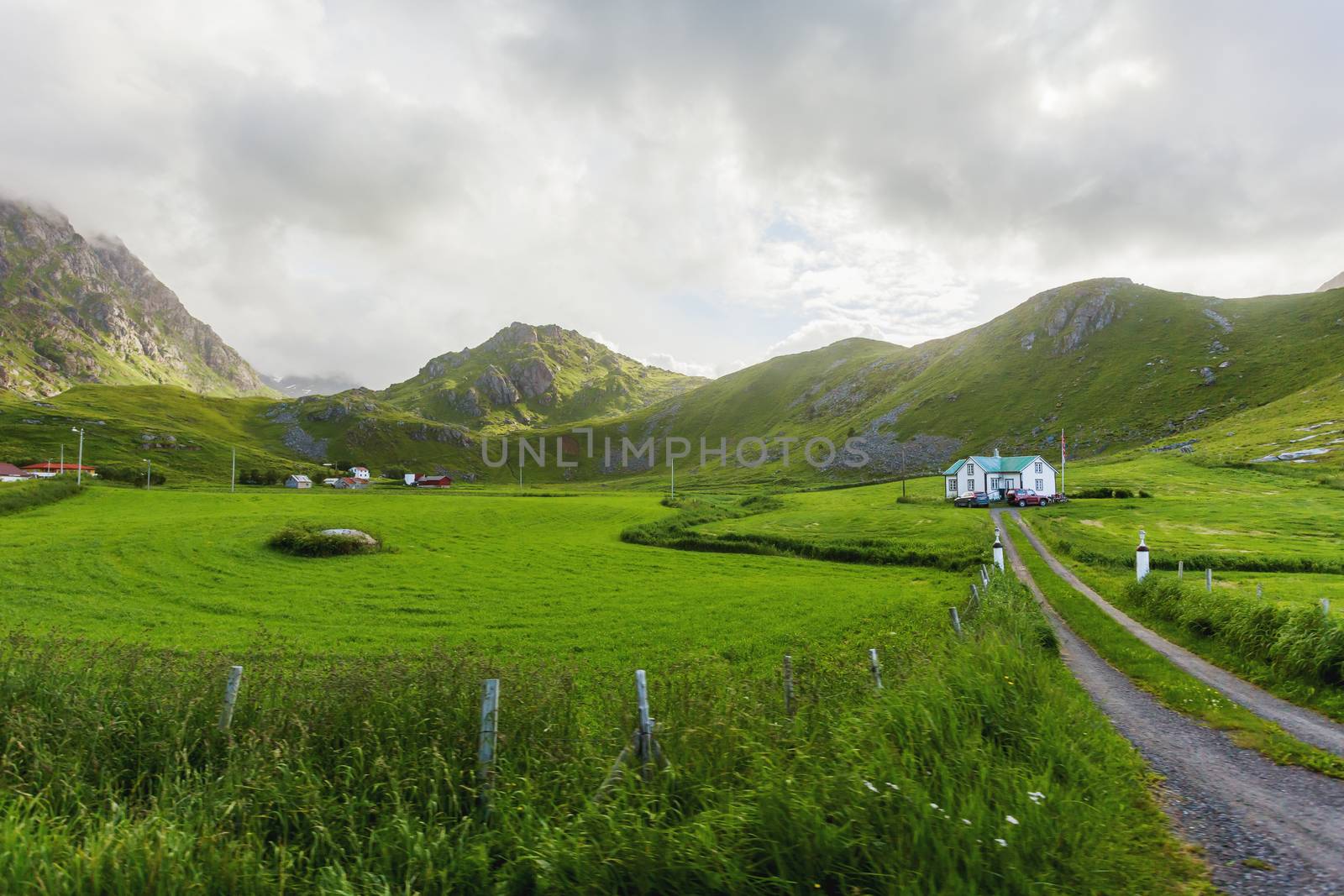 Typical scandinavian landscape with meadows, mountains and village. Lofoten islands, Norway.
