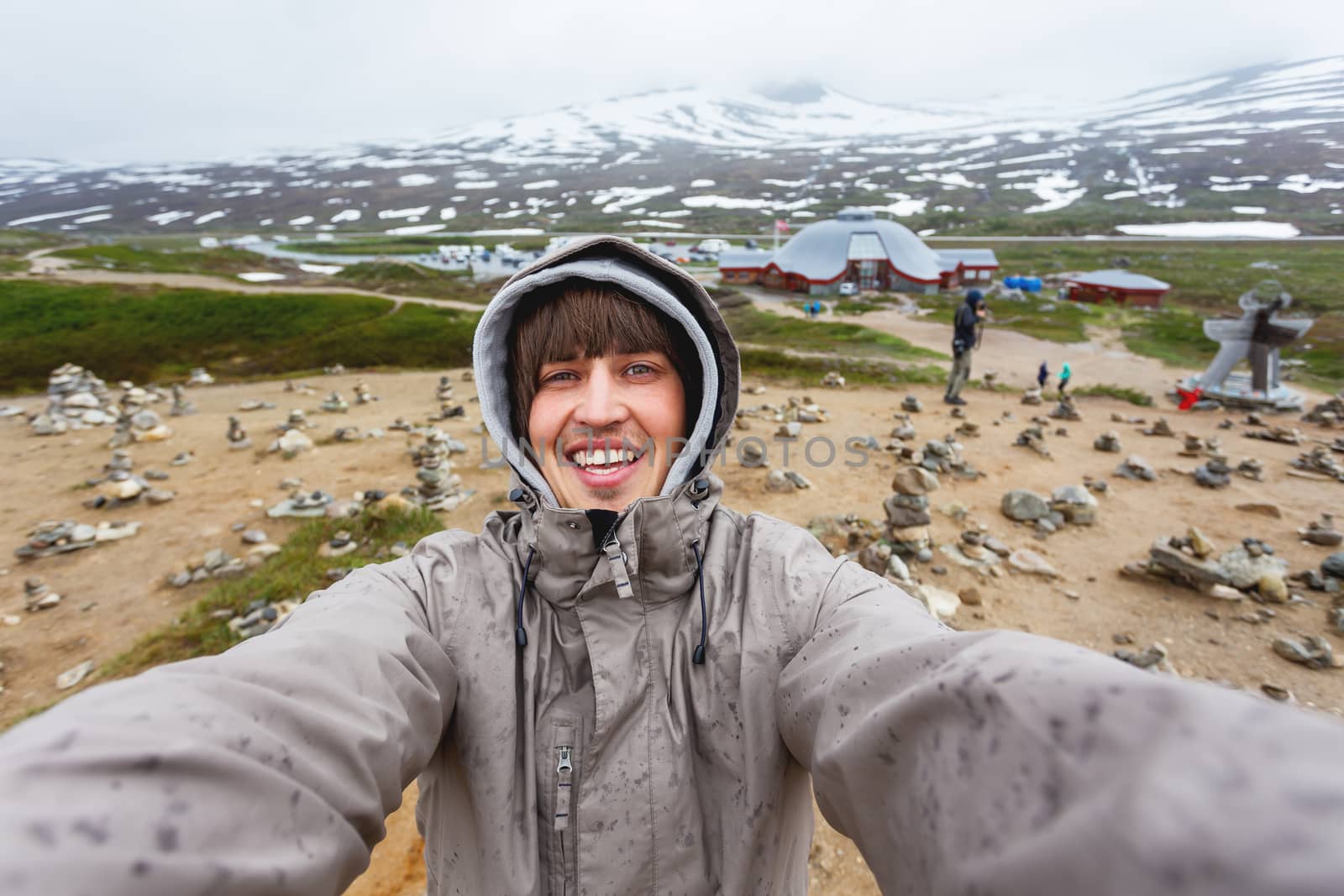 Tourist man making selfie Arctic circle center. Landmark on Lofoten islands. Norway.